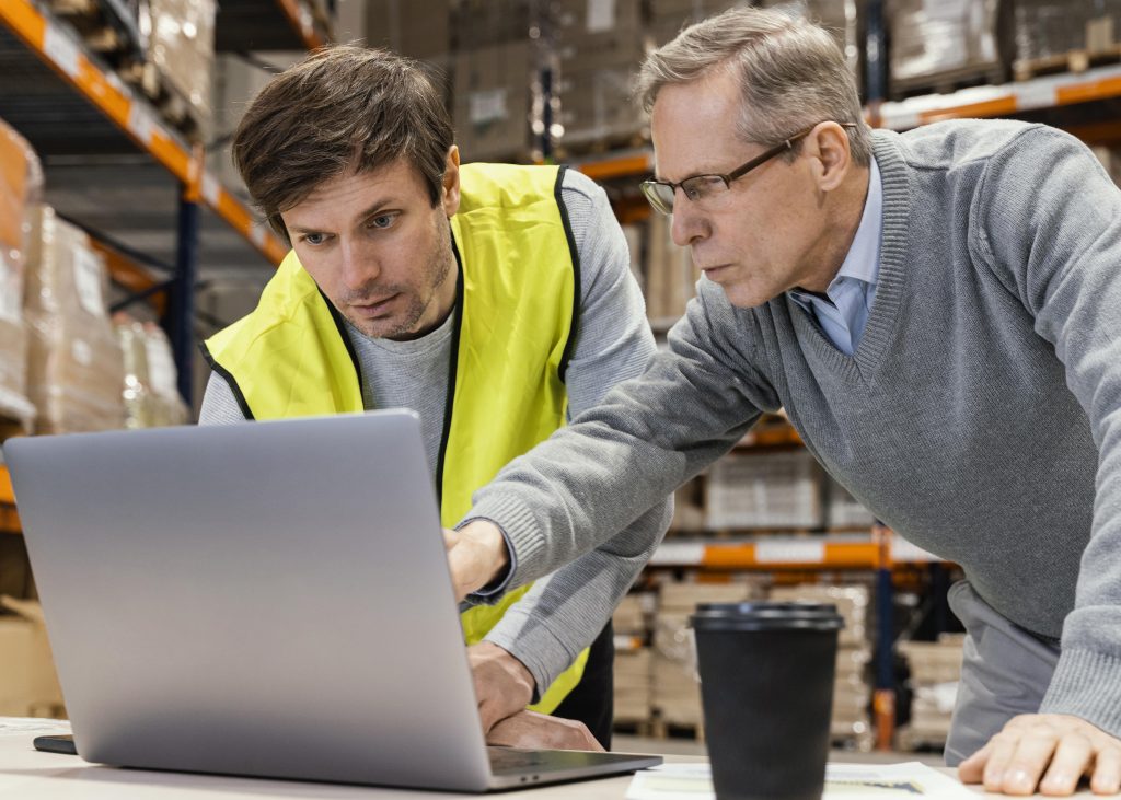 Consultor logístico utiliza software logístico junto a un operario de almacén
