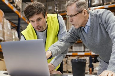 Consultor logístico utiliza software logístico junto a un operario de almacén