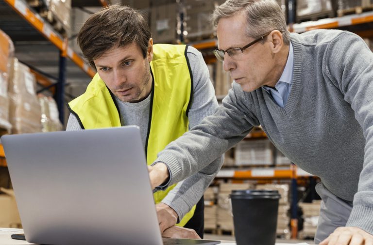 Consultor logístico utiliza software logístico junto a un operario de almacén